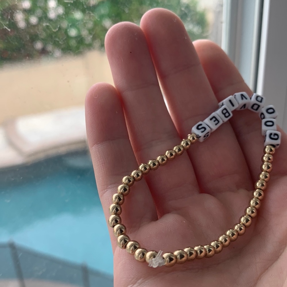 Gold Beaded Bracelet With the Saying Good vibes in Black and White Letters